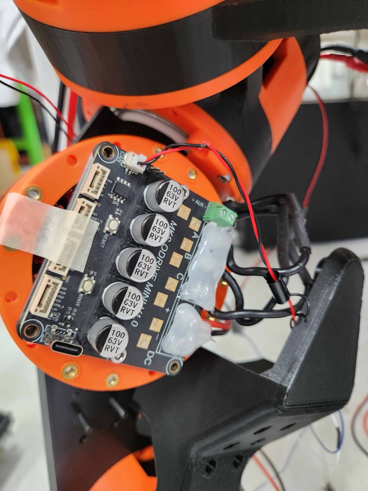 Actuator mounted in the robot leg, with the motor and power wires fixed to the driver board with hot glue over the solder joints.