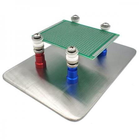 Magnetic PCB holder: a steel base plate with four magnetic posts holding a circuit board above it.