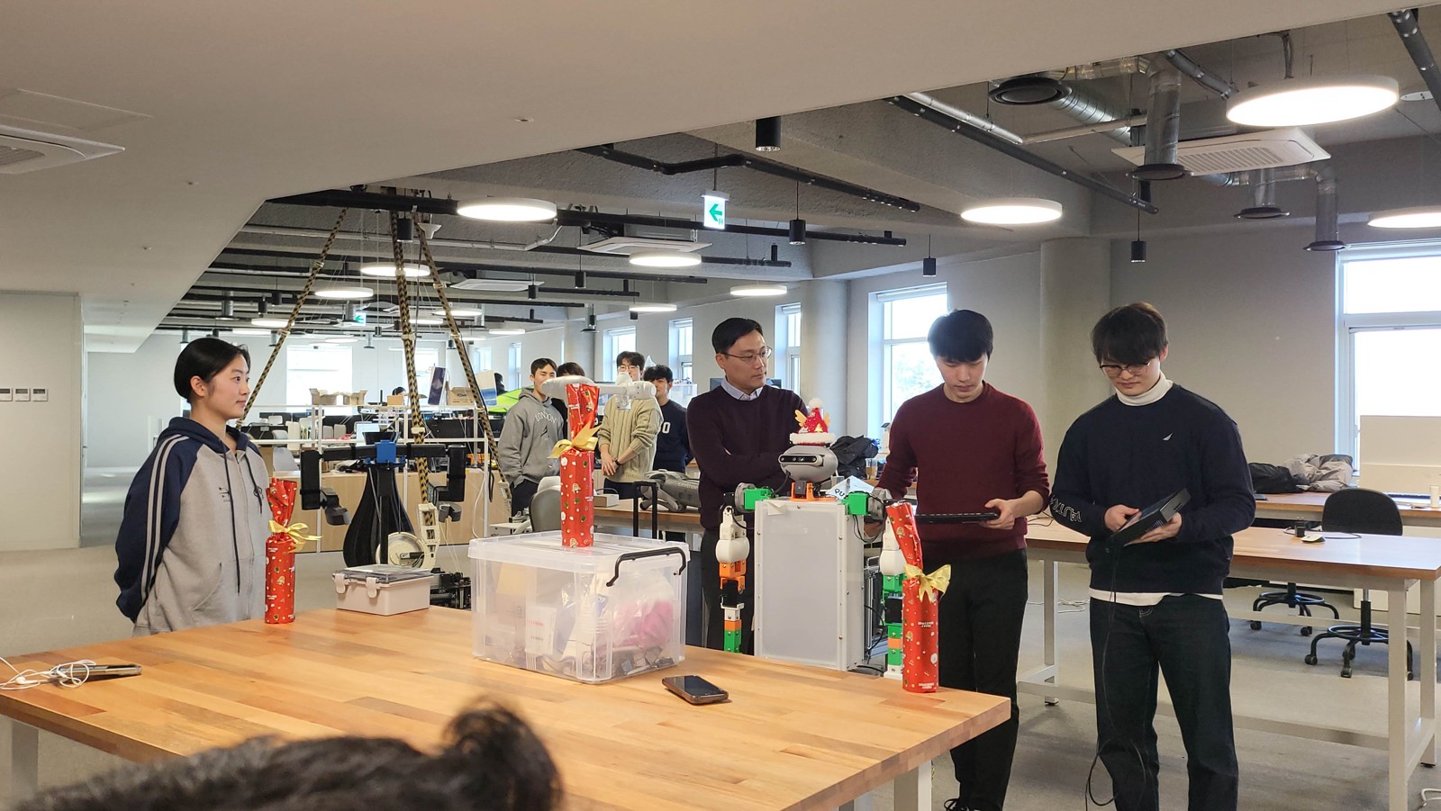 ASMR 2024: students and Professor Yong-Lae Park gathered around the class's humanoid robot during a demo in the lab.