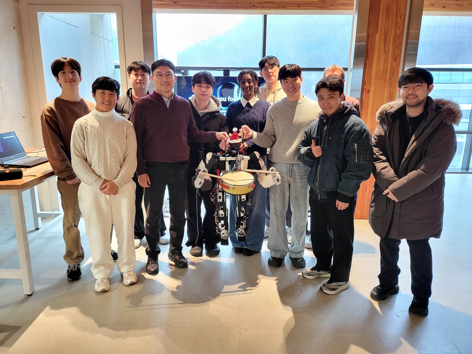 ASMR 2025: students and Professor Yong-Lae Park posing with the class's humanoid robot, which holds drumsticks and a drum.