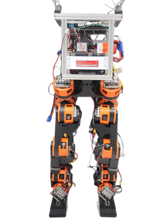 The fully assembled course robot: an aluminum-frame body holding the batteries, power relay, and electronics, on top of two legs built from orange and black 3D-printed actuators and structure parts, standing on flat feet.